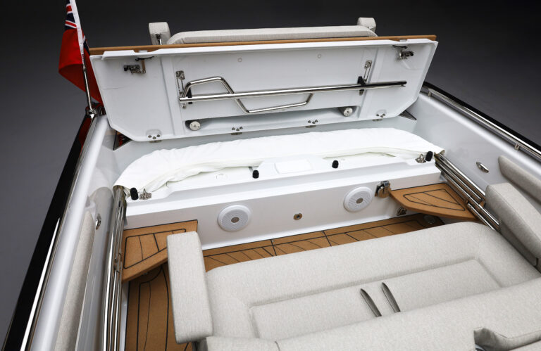Luxury tender boat interior with spacious seating and hidden storage for the bimini beneath a sleek seat, featuring stainless steel handles